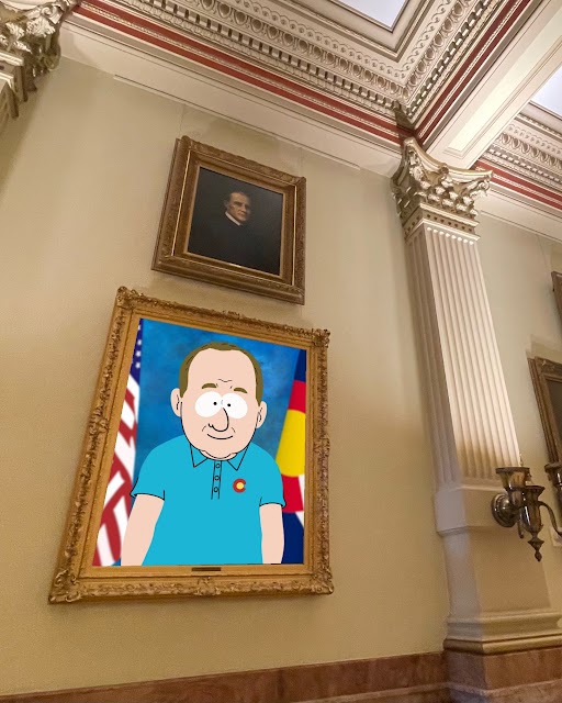 An animated image, inspired by the art of South Park, of Governor Polis standing infront of a Colorado and United States Flag hanging on the wall of the Colorado State Capitol building in a frame.