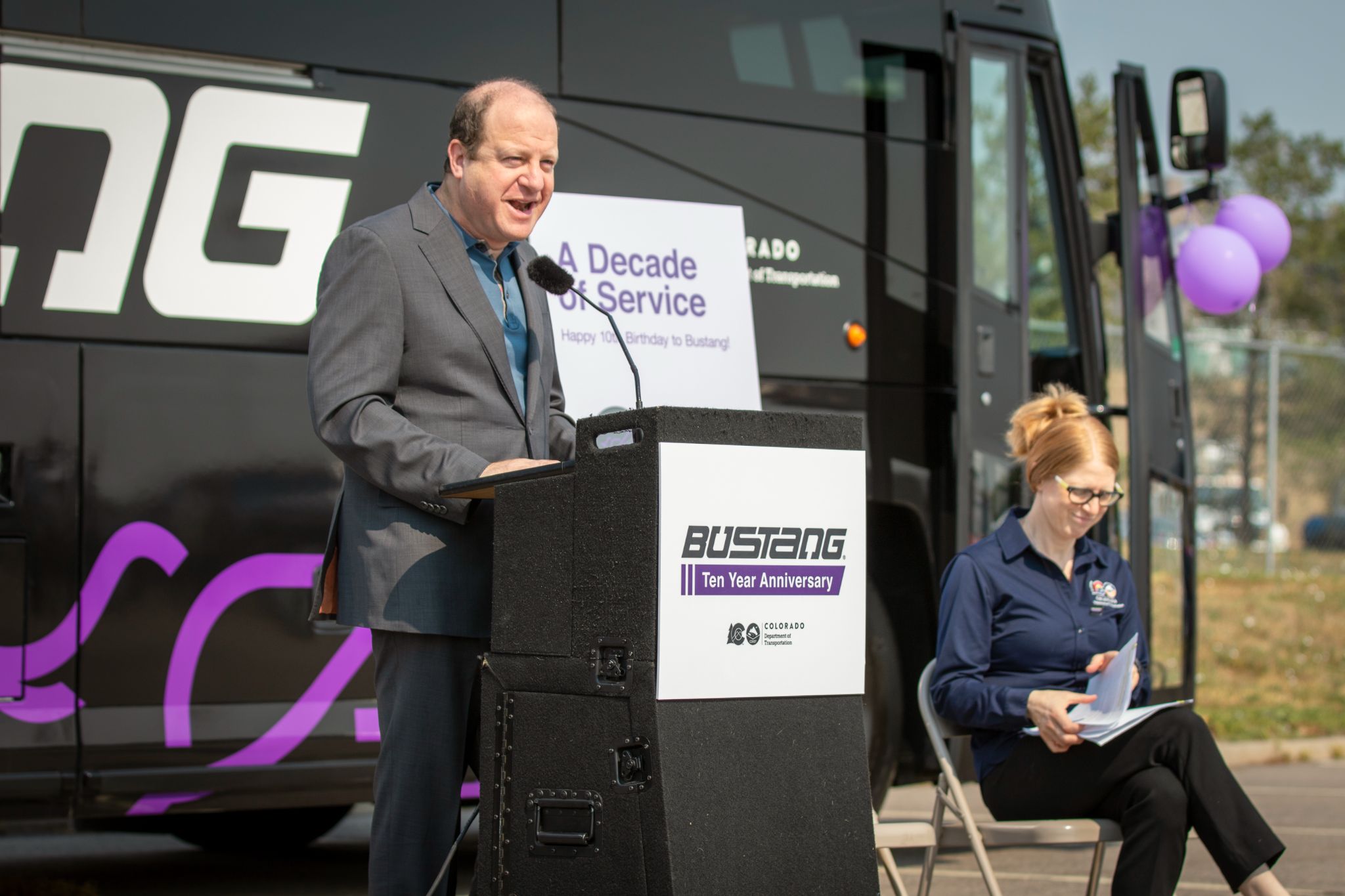 Governor Polis speaks at podium in front of crowd