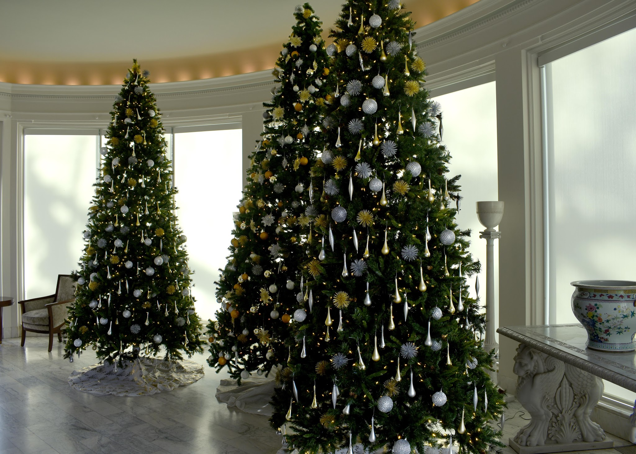 Three christmas trees inside the mansion decorated for christmas
