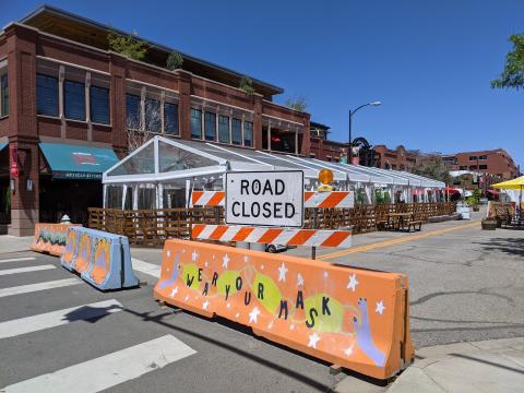 Concrete barrier painted bright orange with Wear Your Mask in black letters.