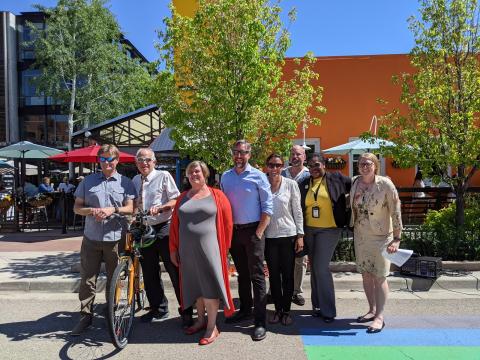 Group of people standing in street. Caption below.